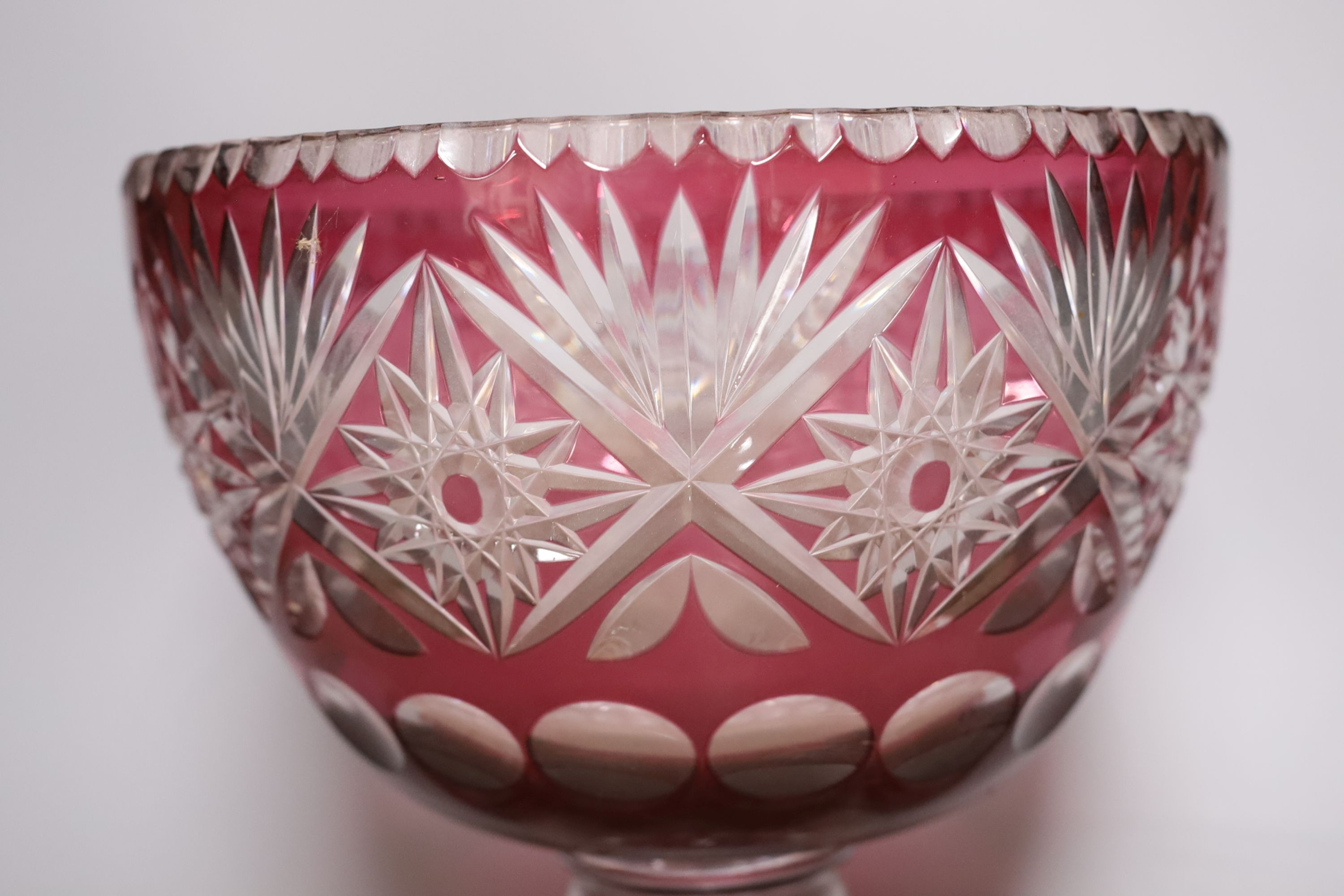 A Bohemian cut glass and cranberry overlay punch bowl with four glasses. Tallest 27cm